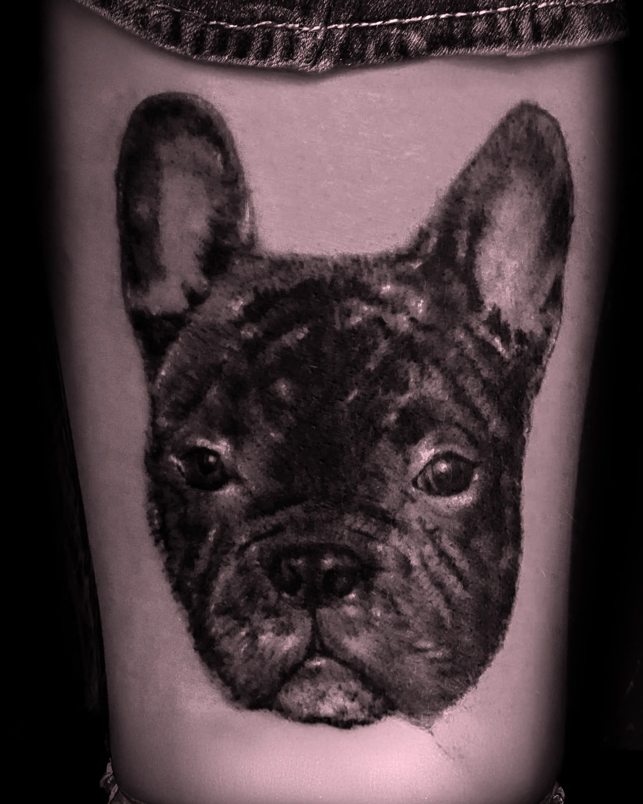 Miniaturowy, niezwykle precyzyjny tatuaż mikrorealistyczny przedstawiający portret postaci w stylu black and grey