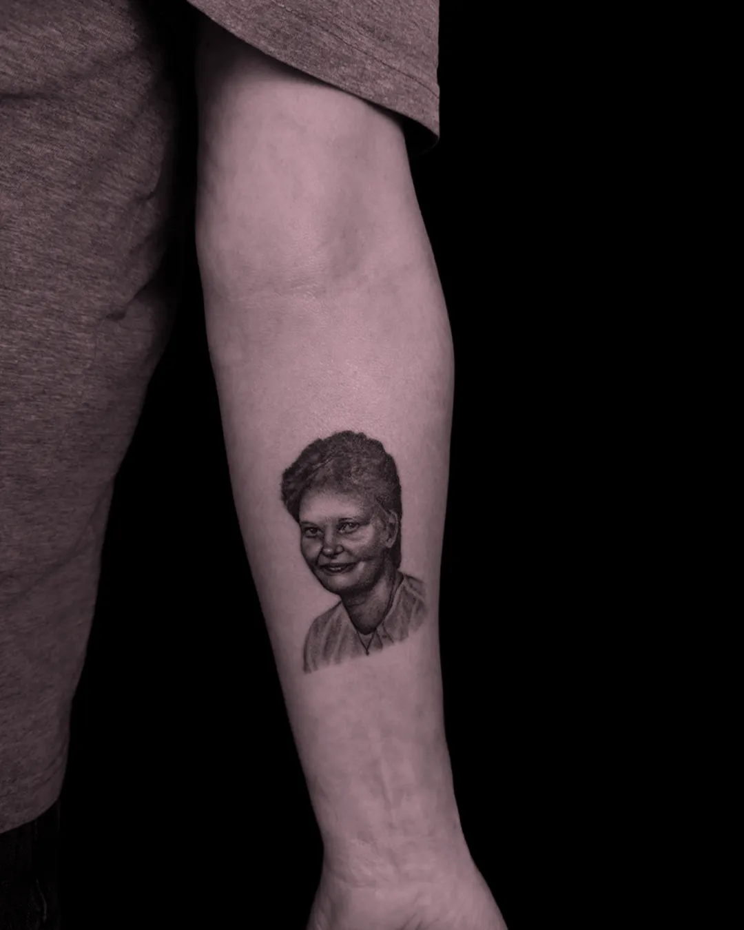 Miniaturowy, niezwykle precyzyjny tatuaż mikrorealistyczny przedstawiający portret postaci w stylu black and grey
